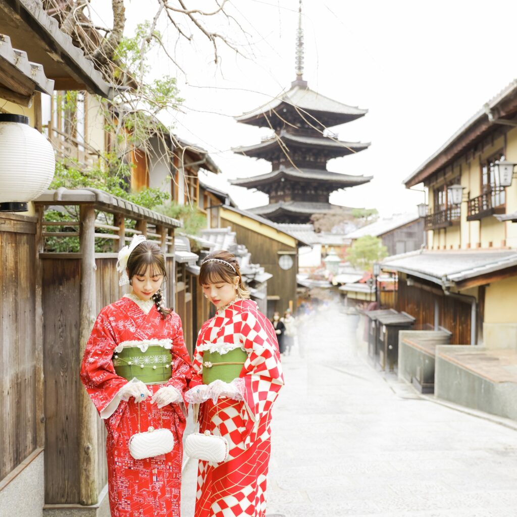 京都の八坂の塔前で京都着物レンタル京小町の赤い着物を着た女性二人が並んで撮影している写真。京都で人気の着物体験。
